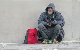  ?? GAVIN YOUNG ?? Darryl panhandles along 1st Street S.E. on Thursday amid bone-chilling temperatur­es Darryl says his key to staying warm is to wear two winter jackets.