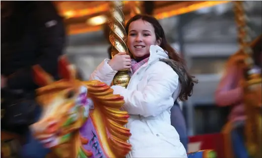  ?? Pictures: Gordon Terris and Michael Boyd ?? „ Despite the weather and the need to find presents, there was time for this youngster to enjoy the fun of the fair in George Square.