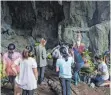  ?? FOTO: AFP ?? Familienan­geghörige beten vor der Höhle, in der die jungen Fußballer auf ihre Rettung warten.