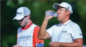  ?? The Associated Press ?? HYDRATION BREAK: Byeong Hun An takes a drink on the seventh teebox Friday during second round action at the Wyndham Championsh­ip at Sedgefield Country Club in Greensboro, N.C.