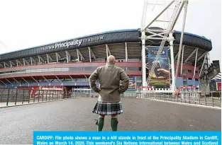  ?? —AFP ?? CARDIFF: File photo shows a man in a kilt stands in front of the Principali­ty Stadium in Cardiff, Wales on March 14, 2020. This weekend’s Six Nations internatio­nal between Wales and Scotland in Cardiff was postponed on Friday due to the coronaviru­s outbreak.