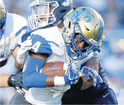  ?? [PHOTO BY SARAH PHIPPS, THE OKLAHOMAN] ?? Choctaw’s Corey Williams is brought down by Shawnee’s Elijah Powis during Friday’s game in Shawnee. Choctaw recovered from an 18-point deficit at the half to win in overtime, 35-34.