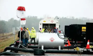  ??  ?? (Top) Crews watch as water is pumped out of the Oktibbeha County Lake in an effort to relieve pressure on the failing dam.