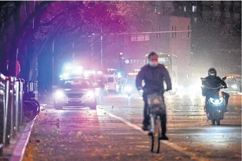  ?? AFP ?? Police vehicles are seen patrolling the streets of Beijing on Monday.