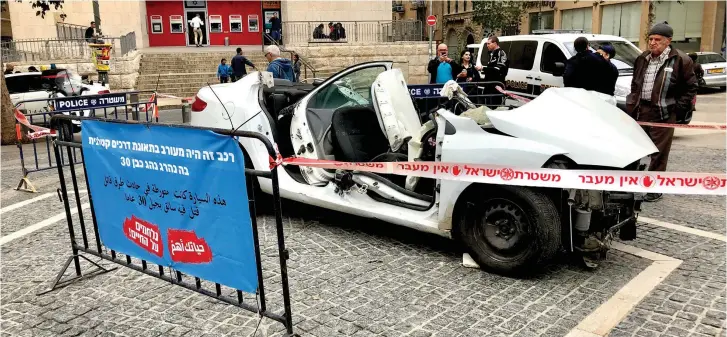  ??  ?? A CAR wreck exhibition surrounded by police tape in Jerusalem’s Zion Square last week.