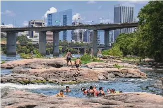  ?? ?? People cool off in the James River at Belle Isle on July 19, 2020, in Richmond, Va.