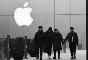  ?? ASSOCIATED PRESS ?? CHINESE MEN WALK PAST the Apple logo in Beijing, China, Jan. 3. The tech giant became the latest global company to collide with Chinese consumer anxiety when CEO Tim Cook said iPhone demand is waning, due mostly to China.