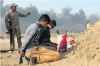  ?? Goran Tomasevic / Reuters ?? Suspected ISIL fighters held by Iraqi forces at a checkpoint in Qayyarah, south of Mosul yesterday.