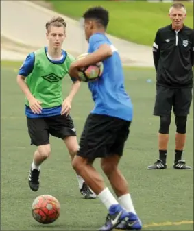  ?? DAVID BEBEE, RECORD STAFF ?? Rookie Michael Halapir, left, goes through a practice drill at WLU with a teammate under the watchful eye of proud dad, Mario, a K-W soccer icon and assistant coach of the United FC.