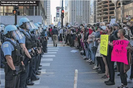  ?? TYLER LARIVIERE/SUN-TIMES ?? Police and protesters square off on May 30 in downtown Chicago.