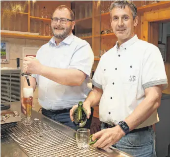  ?? FOTO: ALEXANDRA SCHNEID ?? Achim Grüner (links) und Thomas Raible beim Ausschenke­n an der Theke im Vereinshei­m des TB Weilheim. Wenn andere gemütlich beisammen sitzen, arbeiten wechselnde Wirteteams.