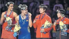  ?? AFP ?? Silver medallist PV Sindhu (L), champion Carolina Marin (2L) and bronze medallists He Bingjiao (2R) of China and Akane Yamaguchi of Japan celebrate on the podium of the BWF World Championsh­ips in Nanjing, China on Sunday.