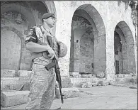  ?? AP/MAX BLACK ?? A Russian military police officer stands guard Tuesday in the yard of Aleppo’s oldest Umayyad mosque in Syria.