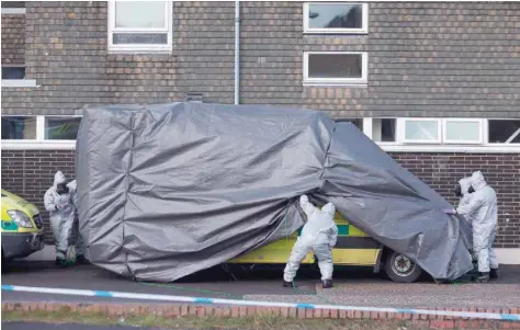  ?? — AFP ?? Personnel in protective coveralls and breathing equipment cover an ambulance with a tarpaulin at the Salisbury District Hospital in Salisbury, southern England, on Sunday in connection with the major incident sparked after a man and a woman were...