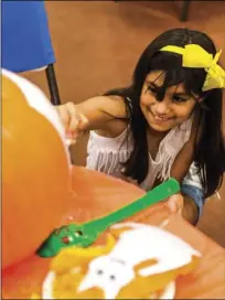  ?? PHOTO VINCENT OSUNA ?? Karissa Ruiz, 11, smiles as she paints a design on her pumpkin during Autism Support of Imperial County’s pumpkin carving and decorating event held Tuesday night at First United Methodist Church in El Centro.