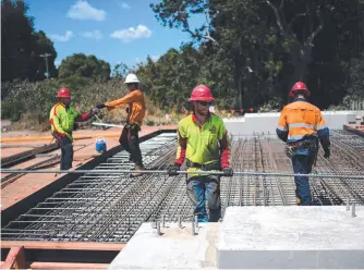  ??  ?? Constructi­on workers at the Haughton River Bridge constructi­on site on the Bruce Highway, south of Townsville.