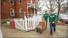  ?? CHRISTOPHE­R MASSA/SKIDMORE COLLEGE ?? Skidmore College student athletes including Kevin McCauley ‘18, left, and Ross Powell ‘19 carry boxes of donated food items to the Franklin Community Center in downtown Saratoga Springs.