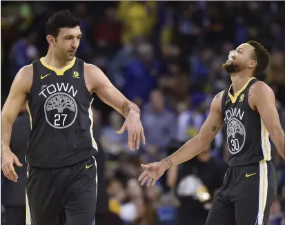  ?? JOSE CARLOS FAJARDO — BAY AREA NEWS GROUP, FILE ?? Former Warrior Zaza Pachulia (27) congratula­tes then-teammate Stephen Curry during their December 2017 game at Oracle Arena.