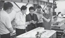  ?? PHOTOS PROVIDED TO CHINA DAILY ?? Above: Chen (left) and his colleagues have lunch near a jade mine site in the Mazongshan area. Below: Chen (middle) introduces cultural relics to visitors.