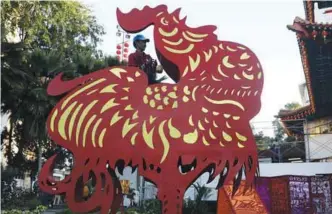  ?? ZULFADHLI ZAKI/ THESUN ?? ... With Chinese New Year around the corner, preparatio­ns are picking up to welcome the Year of the Rooster. A temple worker is seen installing a replica of the bird at the Sin Sze Si Ya Temple in Kuala Lumpur yesterday.