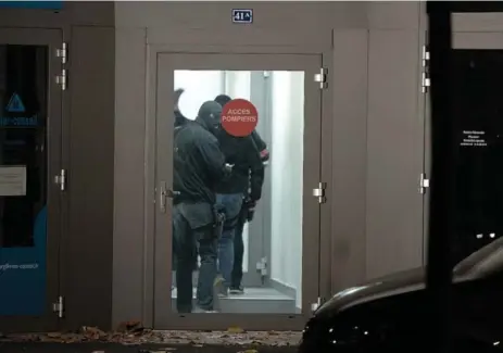  ?? FREDERICK FLORIN/AFP/GETTY IMAGES ?? Officers enter a building Monday in Strasbourg. Police carried out nearly 170 searches and arrested 23 people in raids across France.