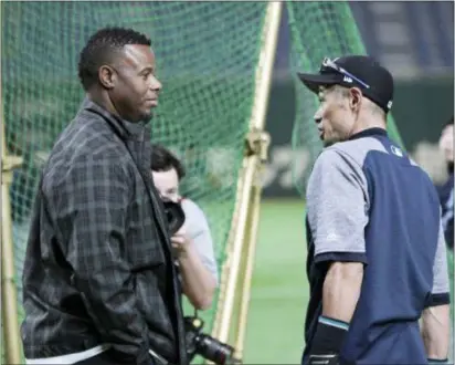  ?? EUGENE HOSHIKO — THE ASSOCIATED PRESS ?? Former Mariners outfielder Ken Griffey Jr., left, talks with Ichiro Suzuki during the team’s practice in Tokyo Saturday. The Mariners will play in a two-game series against the Oakland Athletics to open the season on March 20-21.