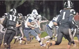  ?? Jan Wright ?? Nate Dunfee navigates his way through the Commerce defense on a wet, muddy night in northeast Georgia. Dunfee had one of the Trojans’ touchdowns on a 53-yard run on their fifth play of the game.