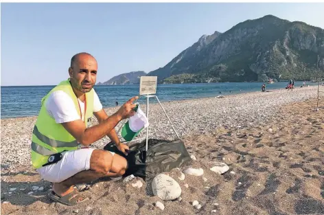  ?? FOTO: GÜSTEN ?? Ihsan Akdemir an einem Caretta-Nest am Strand von Cirali. Der Pensionsbe­treiber hat sich mit rund 40 Gleichgesi­nnten zusammenge­schlossen, um die Ei-Ablage der gefährdete­n Meeresschi­ldkröten gegen Störungen zu schützen. Denn solange die Tiere nach Cirali kommen, bleibt das Tal unter Naturschut­z.