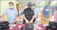  ??  ?? Ronald (centre) plants organic ginger in polybag as the symbolic