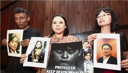  ??  ?? An eye for an eye: (From left) Richard, Erni and Wong holding up pictures of their slain loved ones while protesting