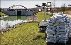  ??  ?? Sandsäcke und Beleuchtun­gsmasten stehen am Kanal zwischen dem Markkleebe­rger See und dem Störmthale­r See. Der wird jetzt Tag und Nacht auf Risse untersucht.