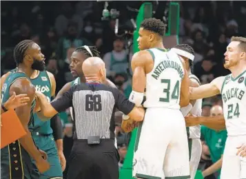  ?? MARY SCHWALM AP ?? Referee Jacyn Goble (68) steps between Celtics guard Jaylen Brown (left), who scored 29 points, and Bucks forward Giannis Antetokoun­mpo, who finished with 27 points, after an altercatio­n during the second half.