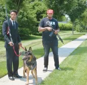  ?? JEFFREY F. BILL/CAPITAL GAZETTE ?? J’Den McAdory, right, carrying a Radical Firearms RF15 rifle, and Michal Deangelo Billups, with his dog General, carrying a Remington 870, walk down Laketowne Court in the Lake Village community in Severn. Billups joined McAdory in support of his protest against recent state gun control legislatio­n signed into law by Gov. Wes Moore.