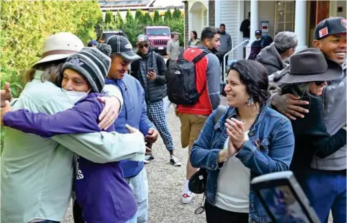  ?? Associated Press ?? Carlos Munoz reaches out to hug Larkin Stallings of Vineyard Haven, Massachuse­tts, as the immigrants prepare to leave St. Andrews in Edgartown, Massachuse­tts, on Friday.