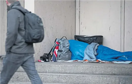  ??  ?? A person sleeping rough in a doorway – a stark illustrati­on of a failing approach to homelessne­ss