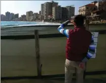  ?? PETROS KARADJIAS, THE ASSOCIATED PRESS ?? A man looks at deserted hotels in the abandoned suburb of Varosha in Famagusta, Cyprus. Author Janet Trull asks: Should the families still displaced from the city be grateful?