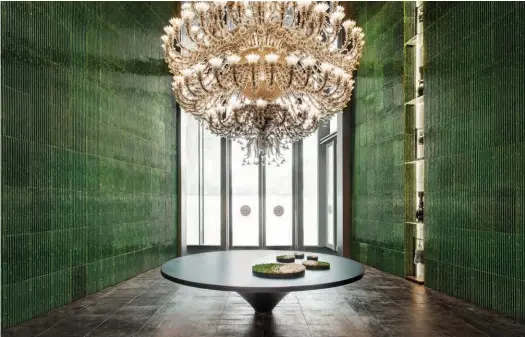  ??  ?? A spectacula­r Murano chandelier makes for a striking impression against a backdrop of a jade green ceramic wall in the main foyer