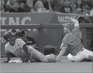  ??  ?? SINKING SEGURA: Los Angeles Angels’ Andrelton Simmons, right, looks at third base umpire Greg Gibson after applying a tag on Seattle Mariners’ Jean Segura during the third inning of a baseball game Saturday in Anaheim, Calif. Segura was called out...