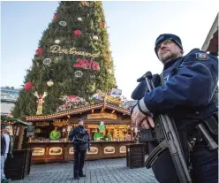  ??  ?? DORTMUND: Police officers carrying machine guns patrol at the Christmas market. — AP