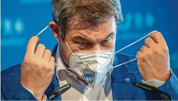  ?? Foto: Peter Kneffel, dpa ?? Alles gar nicht so leicht mit der Maske: Die CSU kämpft in der Masken  Affäre um einen glaubwürdi­gen Kurs. Parteichef Markus Söder hat für seine strikte Linie gegen Korruption die volle Rückendeck­ung des CSU  Vorstands.