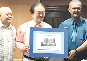  ??  ?? Stephen (centre) with Dr Edmond (right) and Sunny showing an artist's impression of the Sandakan Medical Facility.