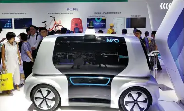  ?? REUTERS ?? Visitors look at a Meituan Autonomous Delivery (MAD) vehicle of Chinese food delivery platform Meituan-Dianping, at the first Smart China Expo in Chongqing in China on Thursday.