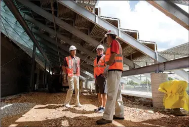  ?? NWA Democrat-Gazette/CHARLIE KAIJO ?? Scott Passmore (from left), district athletic director, West head coach Bryan Pratt and Flintco project manager Scot Hundley stand Monday under the new risers under constructi­on at West High School in Centerton. West’s football stadium is scheduled to host games this fall. Pratt and Hundley gave a media tour to highlight what students and fans can expect.