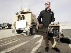  ??  ?? TWENTYNINE PALMS, California: In this Dec 7, 2016 photo, engineer Tyler Wagner displays batteries made to fit into a fuel container during an exhibition of green energy technology. — AP