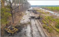  ?? RODRIGO ABD AP ?? Ukrainian soldiers stand amid destroyed Russian armored vehicles in the outskirts of Kyiv, Ukraine, on Thursday.