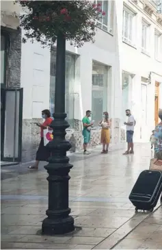  ??  ?? ► Un grupo de turistas camina con sus maletas por la calle Marqués de Larios, en Málaga.