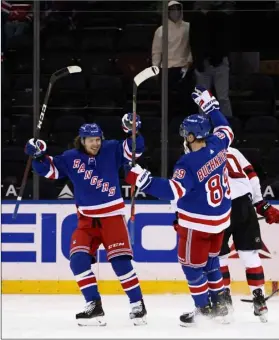  ?? Bruce Bennett/Pool Photo via AP ?? New York Rangers’ Pavel Buchnevich (89) and Artemi Panarin celebrate after Buchnevich scored his third goal against the New Jersey Devils in the third period of an NHL hockey game, on Saturday in New York.