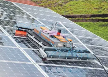  ?? FOTOS: SIMON NILL ?? Saugt sich an den Modulen fest: der Reinigungs­roboter für Photovolta­ik-Anlagen.