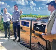  ?? BILL DIPAOLO / THE PALM BEACH POST ?? From left: Jupiter Councilman Ilan Kaufer, Mayor Todd Wodraska and Jeff Sabin of Waste Management unveil the new trash bins at Jupiter Beach.