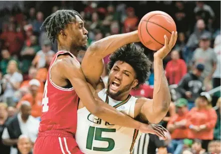  ?? WILFREDO LEE/AP ?? Miami forward Norchad Omier attempts to pass past Louisville forward Jae’Lyn Withers during Saturday’s game in Coral Gables.